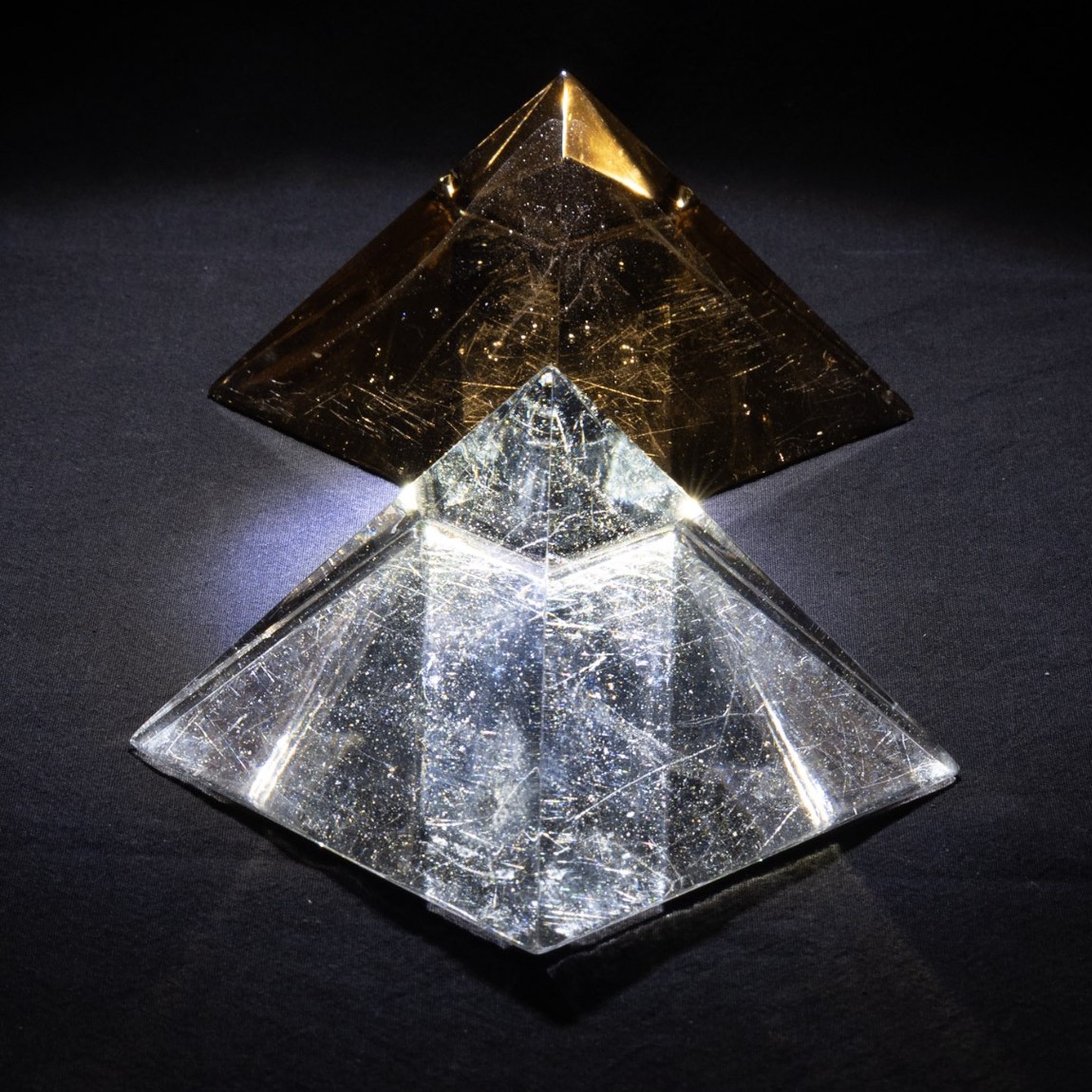 Dyad in Glass, an amber pyramid balanced point-down on a clear one