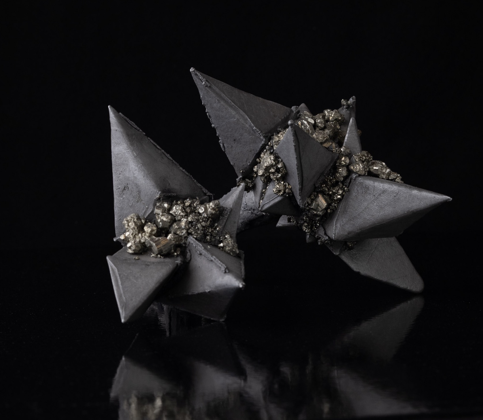 The Weight of Glimmer, a cluster of dark tetrahedra seamed with raw pyrite